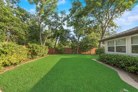 a view of a backyard with large trees