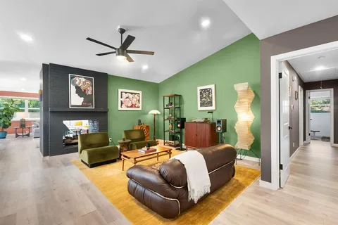 a spacious bedroom with a bed mirror and a fireplace