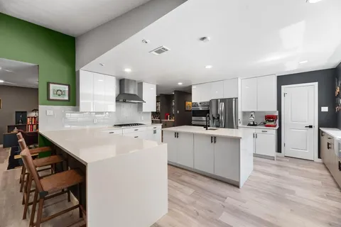 a kitchen with white cabinets and stainless steel appliances