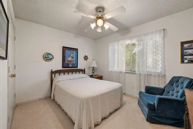 a bedroom with a bed a couch and a chandelier