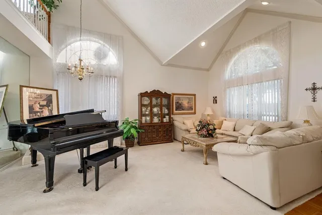 a living room with furniture a chandelier and a piano