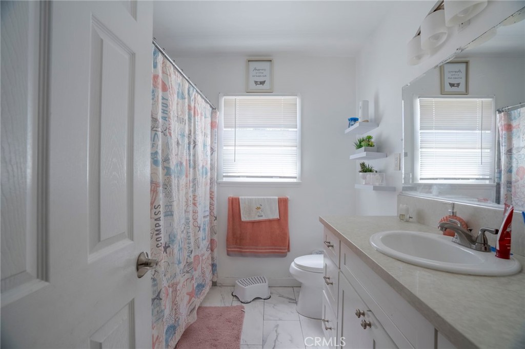 9727 Glandon Street Bellflower, CA 90706 - Photo 12 of 40 a bathroom with a sink toilet and shower