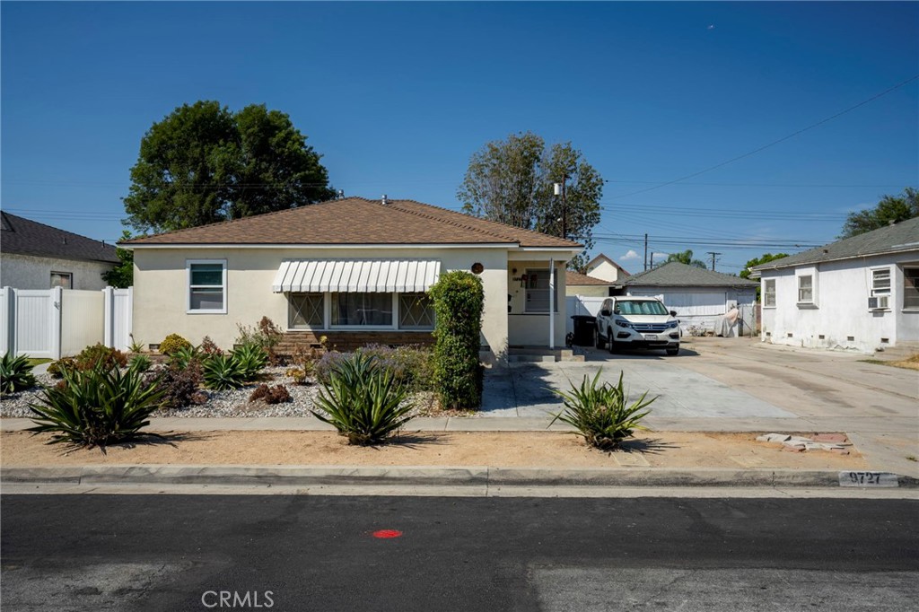 9727 Glandon Street Bellflower, CA 90706 - Photo 39 of 40 a front view of a house with a garden