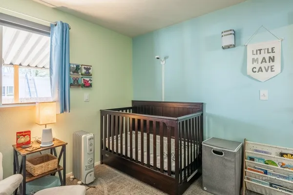 a bedroom with a baby crib and a window