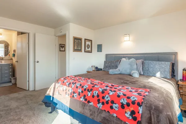 a bedroom with a bed and painting on the wall