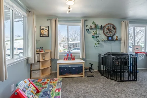 a living room with furniture a baby crib and a window