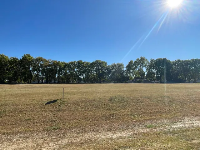 a view of a field with an ocean view