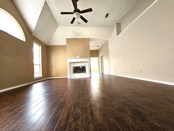 a view of empty room with wooden floor and fireplace