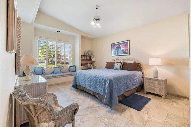 a spacious bedroom with a bed and glass window