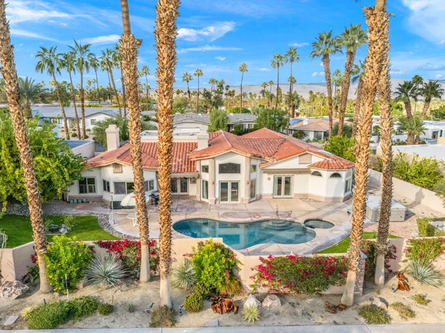 a front view of a house with a yard and fountain