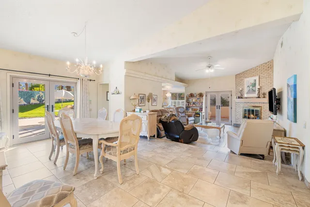 a living room with furniture a dining table and a chandelier