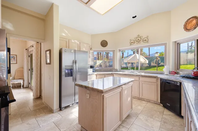 a kitchen with stainless steel appliances granite countertop a refrigerator and a sink