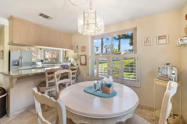 a view of a dining room with furniture a chandelier and wooden floor