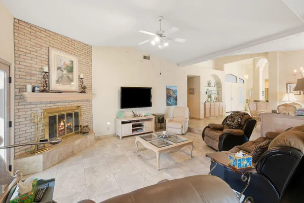 a living room with furniture a fireplace and a flat screen tv