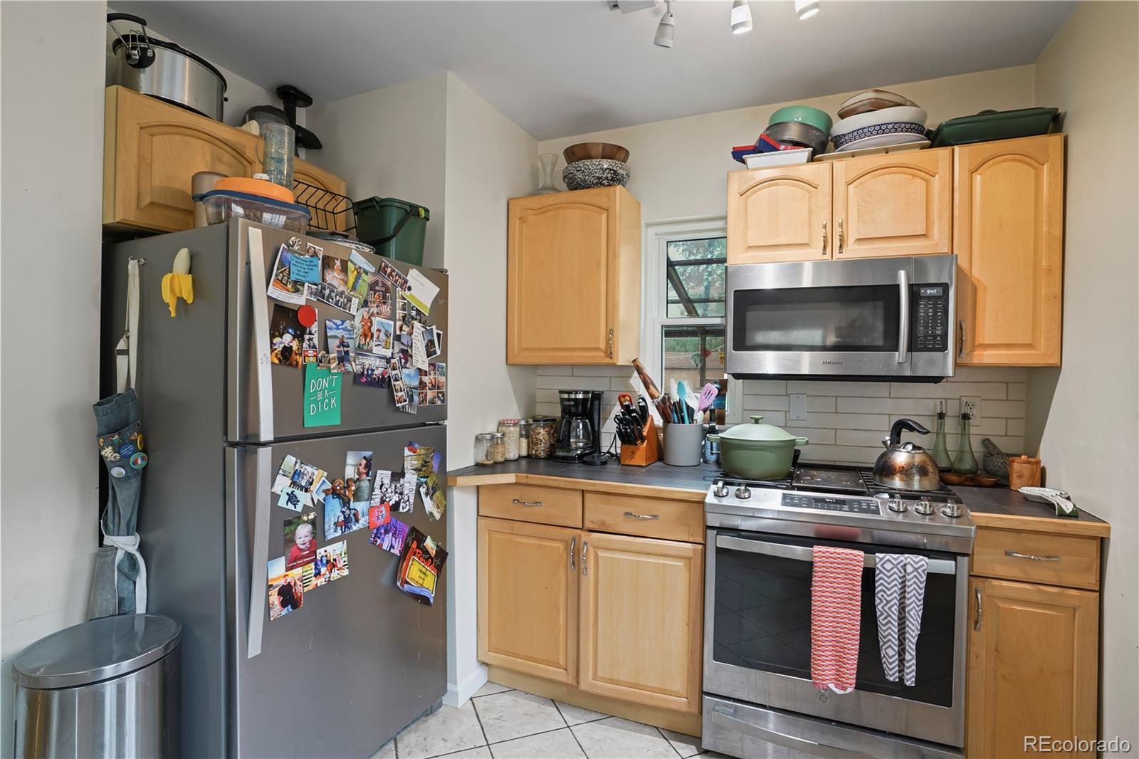 2690 Ash Street Denver, CO 80207 - Photo 8 of 20 a kitchen with stainless steel appliances a stove a sink and a refrigerator