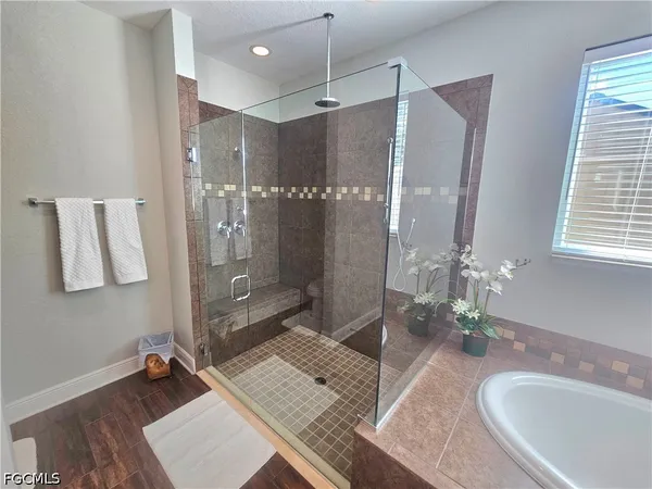 a bathroom with a granite countertop sink a mirror a vanity and shower