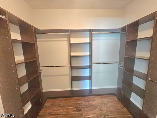 a view of walk in closet with empty racks