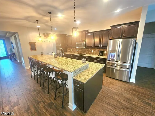 a kitchen with granite countertop counter space a sink appliances and wooden floor