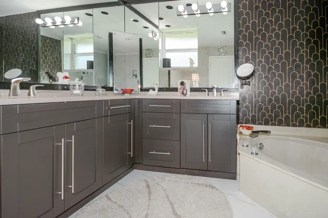a bathroom with a tub sink and mirror