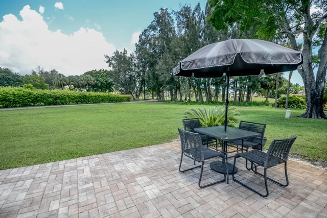 a view of a table and chairs in backyard of the house