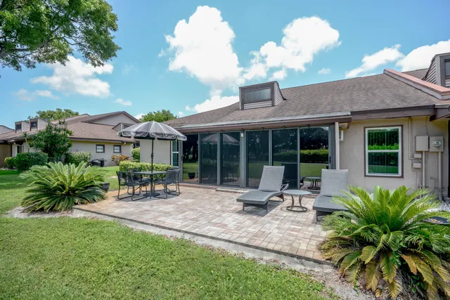 a view of a house with a backyard and sitting area