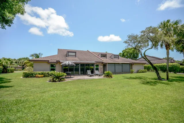 a view of a house with a yard and sitting area