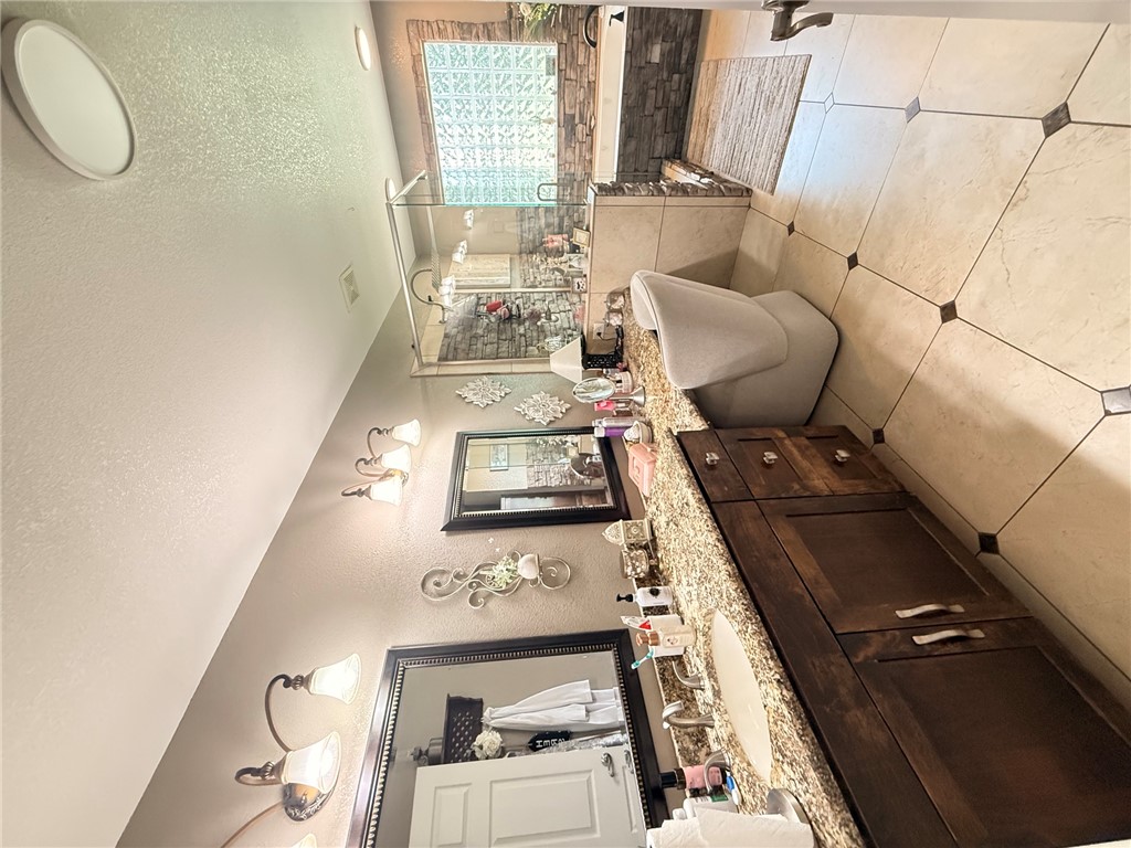 1224 River Road Pottsville, AR 72858 - Photo 6 of 37 Bathroom featuring a dual vanity with granite countertops, wood-finish cabinetry, and framed mirrors