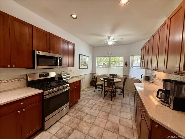 a kitchen with granite countertop a stove top oven microwave and dining table