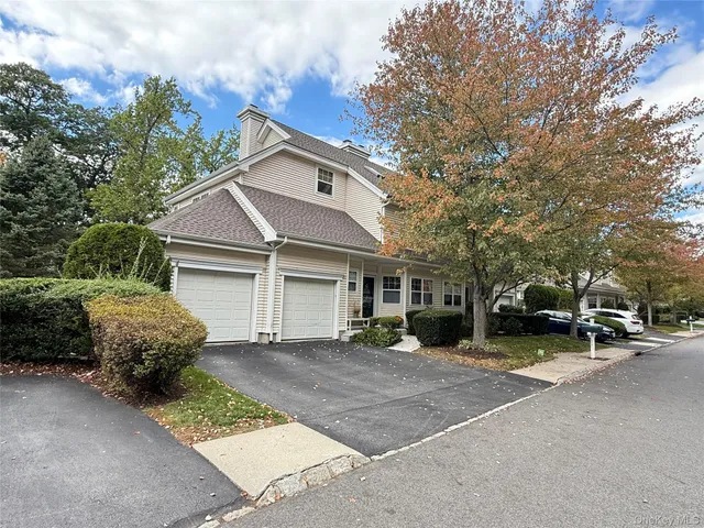 a view of a white house with a large space in front of it