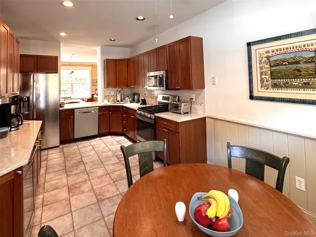 a kitchen with stainless steel appliances wooden floor dining table and chairs