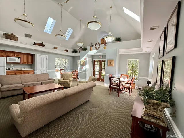 a living room with furniture kitchen view and a large window