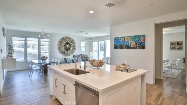 a living room with furniture kitchen view and a large window