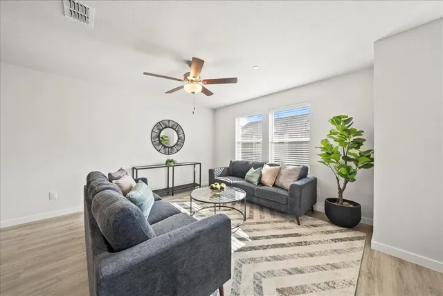 a living room with furniture a chandelier and a window