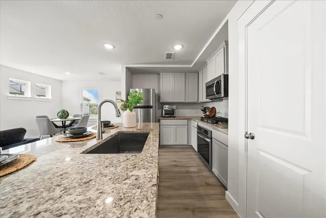 a kitchen with sink a stove and cabinets