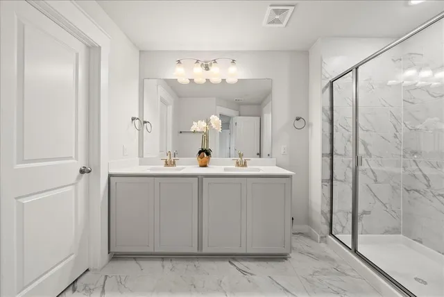 a bathroom with a double vanity sink mirror and shower