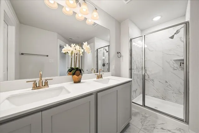 a bathroom with a double vanity sink mirror and shower
