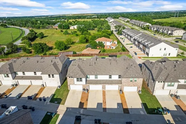 an aerial view of residential houses with outdoor space and swimming pool