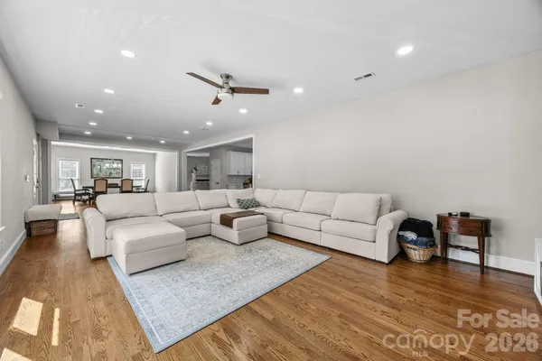 a living room with furniture and view of kitchen