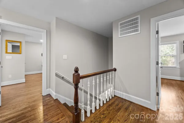 a view of a hallway with wooden floor and a living room