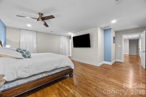 a spacious bedroom with a bed and a flat screen tv