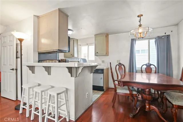 a dining room with furniture a chandelier and wooden floor
