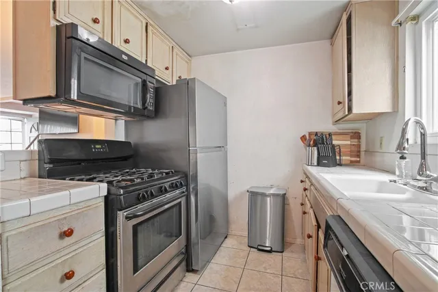 a kitchen with stainless steel appliances granite countertop a stove microwave and sink