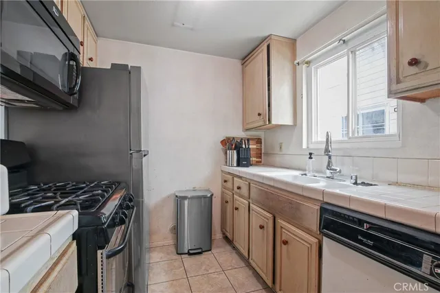 a kitchen with stainless steel appliances a sink stove and cabinets