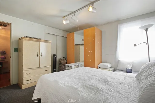 a bedroom with a bed and a large mirror