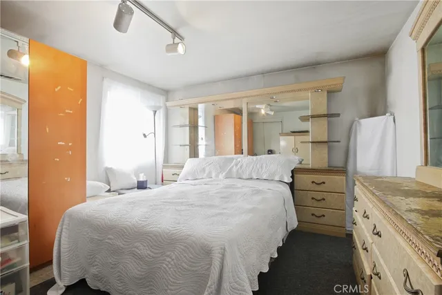 a bedroom with a bed and dresser with mirror