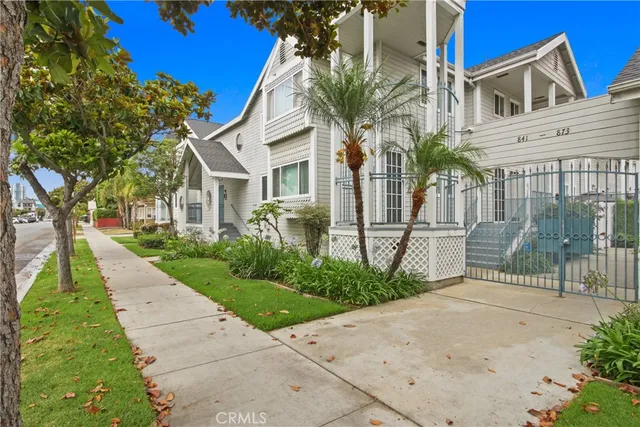 a view of a white house with a small yard and plants