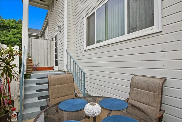 a view of a patio with chairs and potted plants