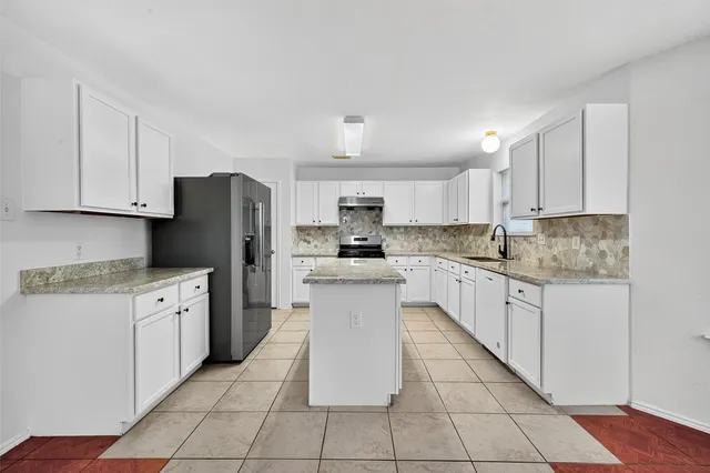 a kitchen with stainless steel appliances granite countertop a refrigerator sink and cabinets