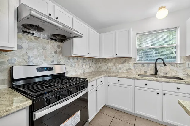 a kitchen with white cabinets and appliances