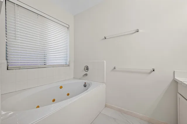 a bathroom with a bathtub and a window